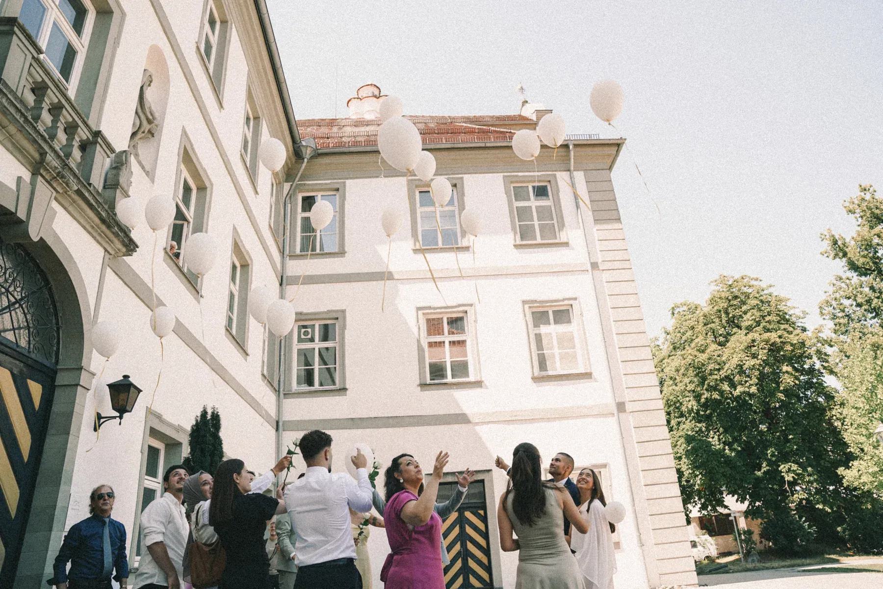Hochzeitsgesellschaft vor einem Gebäude